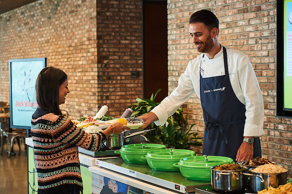 An Aramark chef serving a burrito to an employee.